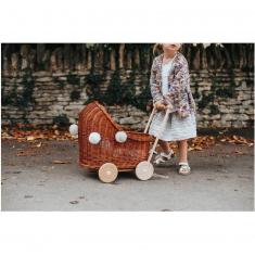 Niedriger Kinderwagen aus Korbgeflecht mit natürlichen Pompons